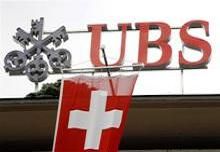 A Swiss flag flies in front of the logo of Swiss bank UBS at the company's headquarters in Zurich